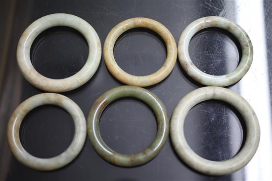 A collection of eighteen Chinese grey and green jade excavated bangles, Ming dynasty or earlier, each approx. 7.4cm diameter